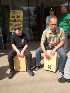 Lehrer und Schüler trommeln gemeinsam.